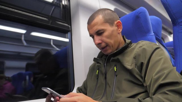 traveler unknown middle-aged man smartphone in the subway writes sms to social media messenger. slow motion video. man metro in railway train. lifestyle man traveler in train concept travel