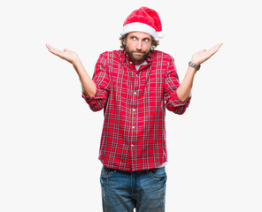 Handsome hispanic man model wearing santa claus christmas over isolated background clueless and confused expression with arms and hands raised. Doubt concept.
