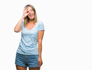 Young beautiful woman over isolated background doing ok gesture with hand smiling, eye looking through fingers with happy face.