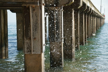 water splashing a pier at a beach in Victoria, Australia