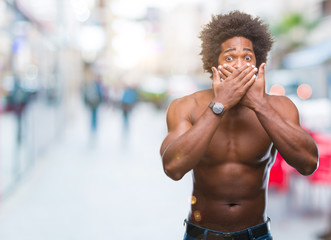 Fototapeta na wymiar Afro american shirtless man showing nude body over isolated background shocked covering mouth with hands for mistake. Secret concept.