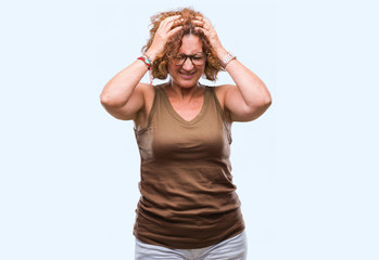 Middle age hispanic woman wearing glasses over isolated background suffering from headache desperate and stressed because pain and migraine. Hands on head.