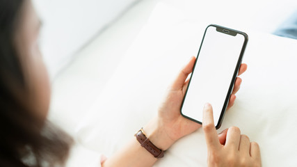 Woman using blank screen of smartphone on room, During leisure time. The concept of using the phone is essential in everyday life.