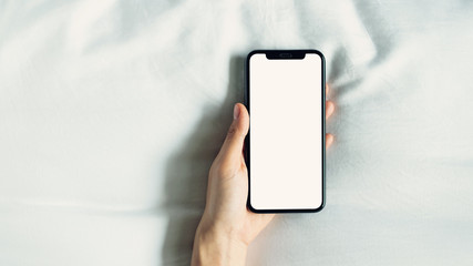 hand using blank screen of smartphone on room, During leisure time. The concept of using the phone is essential in everyday life.