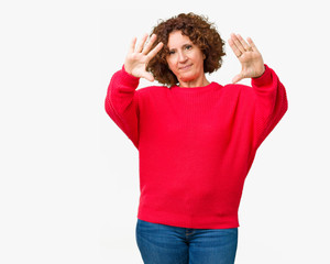 Beautiful middle ager senior woman red winter sweater over isolated background Smiling doing frame using hands palms and fingers, camera perspective
