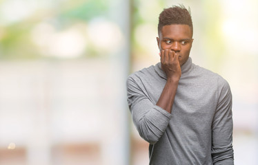 Young african american man over isolated background looking stressed and nervous with hands on mouth biting nails. Anxiety problem.