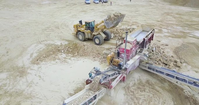 Aerial View of Bulldozer Unloading into Rock Crusher