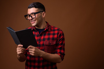 Portrait of young handsome man against brown background