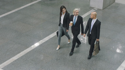 corporate executives walking across lobby of office building