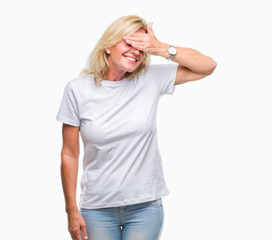 Fototapeta premium Middle age blonde woman over isolated background smiling and laughing with hand on face covering eyes for surprise. Blind concept.