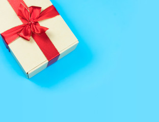 Gift box with red ribbon on blue background.