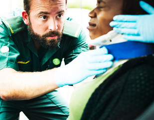 Paramedic placing a cervical collar to an injured woman from car accident
