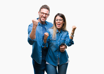 Young couple in love wearing glasses over isolated background very happy and excited doing winner gesture with arms raised, smiling and screaming for success. Celebration concept.