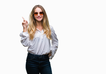 Obraz na płótnie Canvas Young beautiful blonde woman wearing sunglasses over isolated background pointing finger up with successful idea. Exited and happy. Number one.