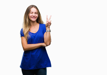 Young beautiful blonde woman over isolated background smiling with happy face winking at the camera doing victory sign. Number two.