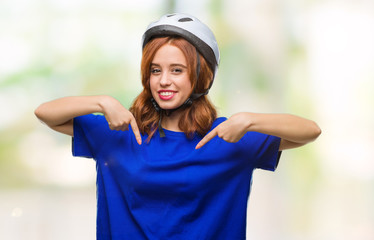 Young beautiful woman wearing cyclist helmet over isolated background looking confident with smile on face, pointing oneself with fingers proud and happy.