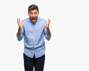 Fototapeta premium Young handsome man over isolated background celebrating crazy and amazed for success with arms raised and open eyes screaming excited. Winner concept