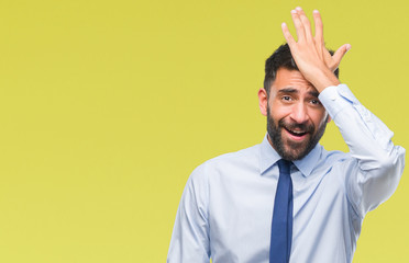 Adult hispanic business man over isolated background surprised with hand on head for mistake,...