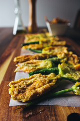 Fried zucchini squash courgette flowers on a wooden table. Italian appetiser.