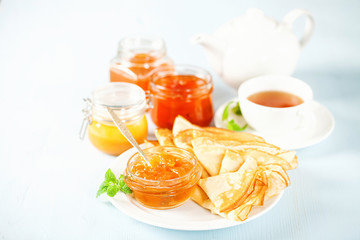 Pancakes with jam, honey and tea.