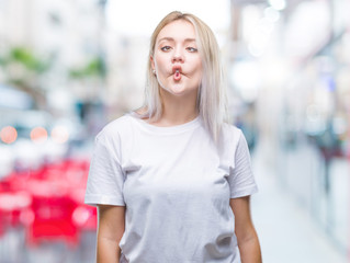 Young blonde woman over isolated background making fish face with lips, crazy and comical gesture. Funny expression.