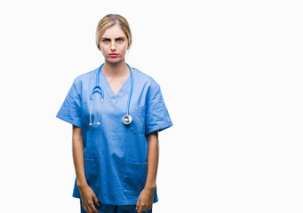 Young beautiful blonde doctor surgeon nurse woman over isolated background skeptic and nervous, frowning upset because of problem. Negative person.