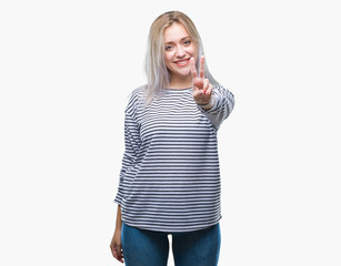 Young blonde woman over isolated background smiling with happy face winking at the camera doing victory sign. Number two.