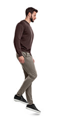 Naklejka premium A serious looking bearded man in casual clothes stands in side view as if on a slope.
