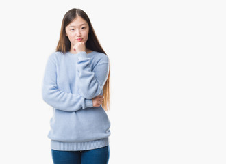 Young Chinese woman over isolated background looking confident at the camera with smile with crossed arms and hand raised on chin. Thinking positive.