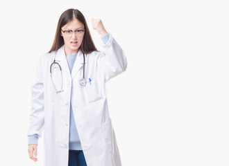 Young Chinese doctor woman over isolated background angry and mad raising fist frustrated and furious while shouting with anger. Rage and aggressive concept.