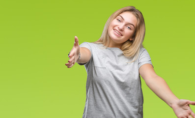 Young caucasian doctor woman wearing surgeon uniform over isolated background success sign doing positive gesture with hand, thumbs up smiling and happy. Looking at the camera with cheerful expression