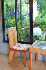 Rattan chair and small table in nature cafe near the garden plant.