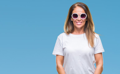 Middle age hispanic woman wearing fashion sunglasses over isolated background with a happy and cool smile on face. Lucky person.