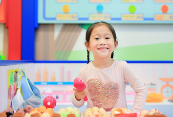 Little girl playing pretend as a sale in ice-cream shop
