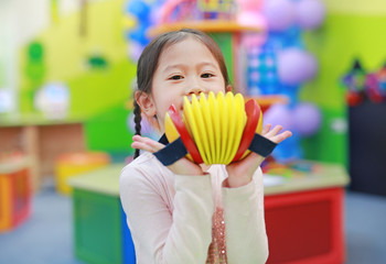 Asian kid girl having fun with Toys, musical instruments.