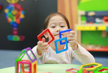 Little child girl playing Magnets toy for brain development.