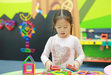 Little child girl playing Magnets toy for brain development.