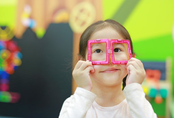 Little child girl playing Magnets toy for brain development.