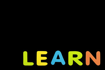 Alphabet sponge rubber of text "LEARN" isolated over black background with copy space.