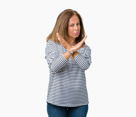 Beautiful middle age woman wearing stripes sweater over isolated background Rejection expression crossing arms doing negative sign, angry face