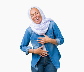 Middle age eastern arab woman wearing arabian hijab over isolated background Smiling and laughing hard out loud because funny crazy joke. Happy expression.