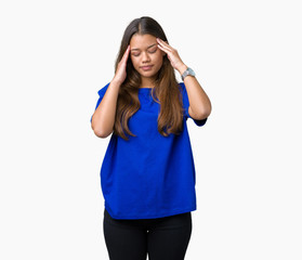 Obraz na płótnie Canvas Young beautiful brunette woman wearing blue t-shirt over isolated background with hand on head for pain in head because stress. Suffering migraine.