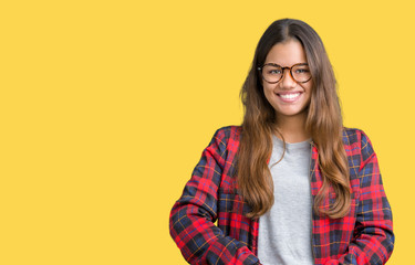 Fototapeta premium Young beautiful brunette woman wearing jacket and glasses over isolated background Hands together and fingers crossed smiling relaxed and cheerful. Success and optimistic