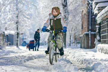 Young boy enjoying cycling on winter sunny day