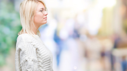 Fototapeta premium Young beautiful blonde woman wearing winter sweater and glasses over isolated background looking to side, relax profile pose with natural face with confident smile.
