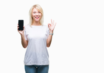 Young beautiful blonde woman showing screen of smartphone over isolated background doing ok sign with fingers, excellent symbol