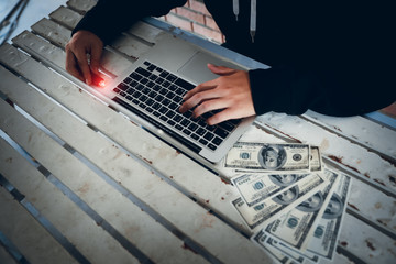 hacker wearing black hooded hacking and stealing big data and finance information from computer and...