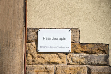 Ein Schild an der Mauer einer Praxis für Paartherapie