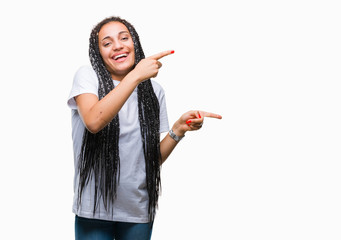 Young braided hair african american girl over isolated background smiling and looking at the camera pointing with two hands and fingers to the side.