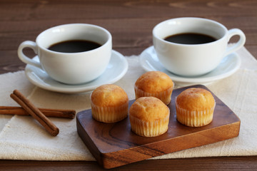 木のテーブルにのせた カップケーキ ホット コーヒー カップ